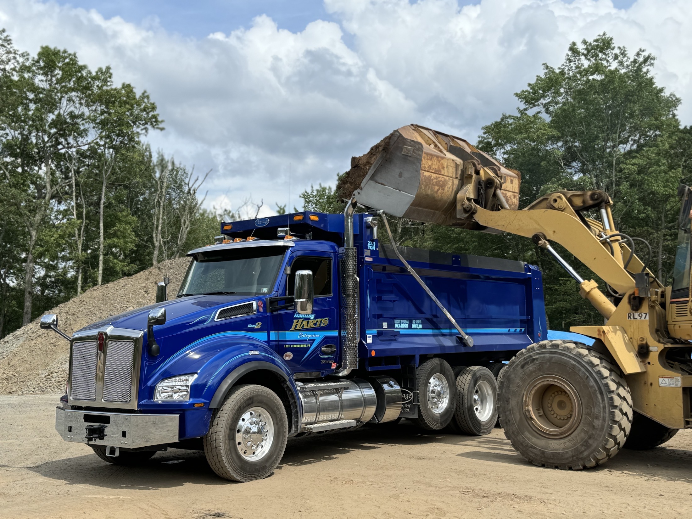 Loader placing material into a Hauling Harts dump truck
