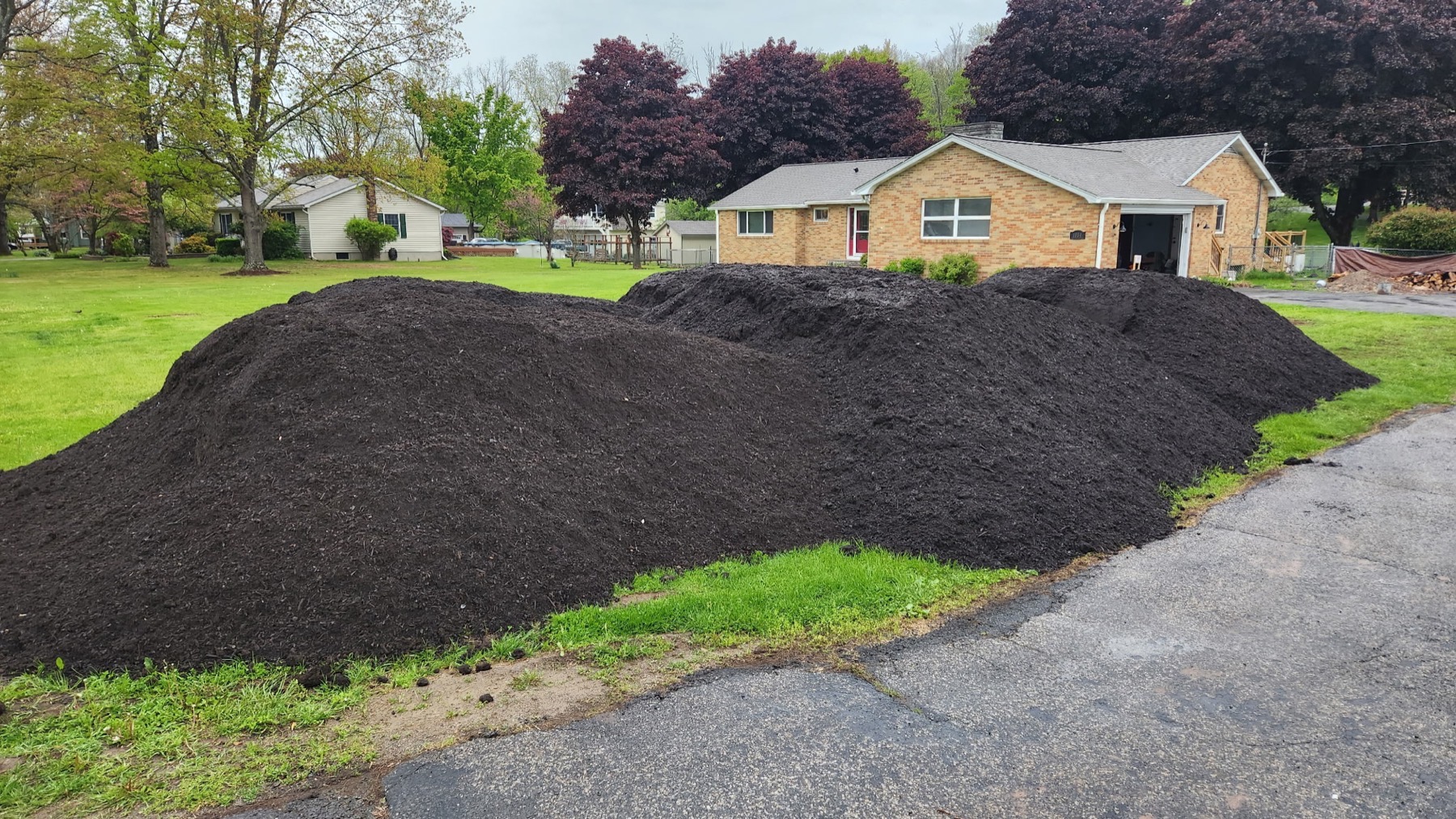 Large mulch delivery in front of a residential property