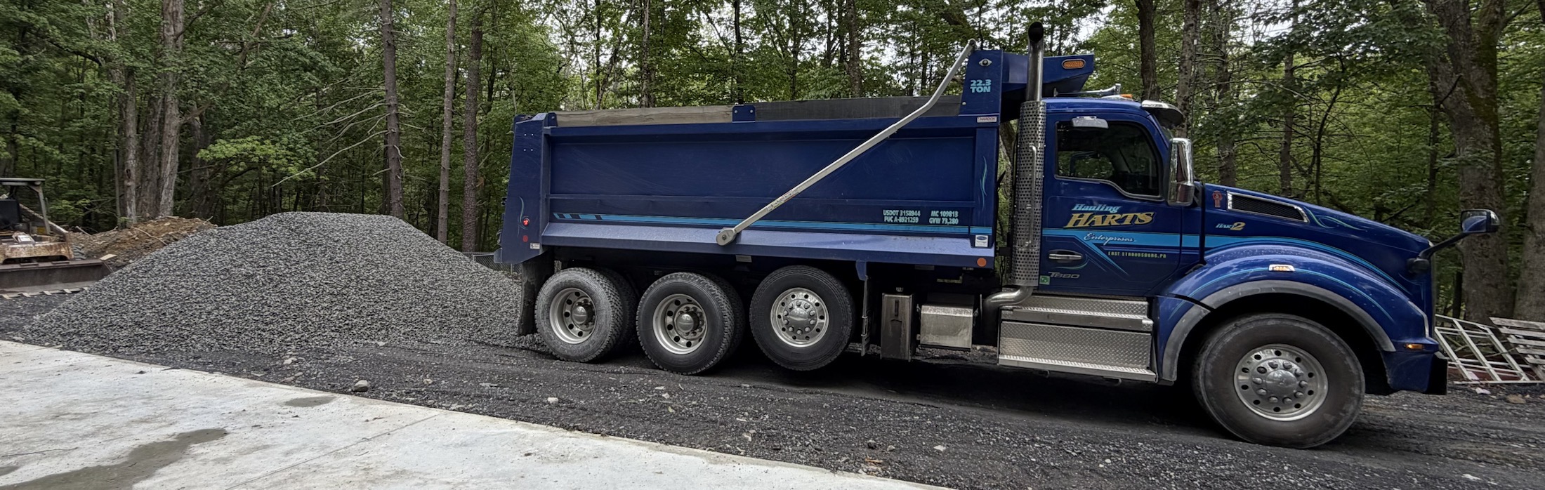 Hauling Harts truck beside a stone pile